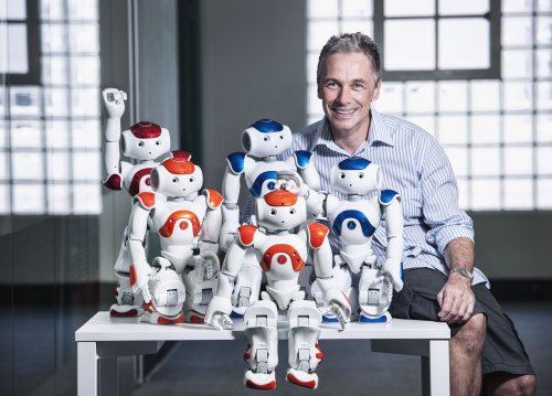 ヒューマノイドロボットが並ぶ研究室と研究者
