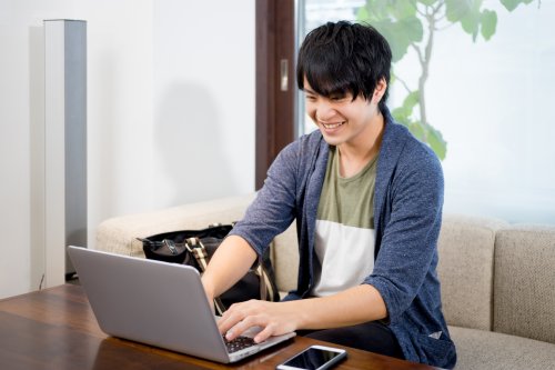 ノートパソコンで書類を確認する男性