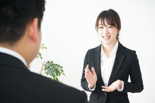 オフィスで説明をする女性スタッフ