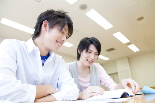 白衣を着た2人が机で資料を見ている