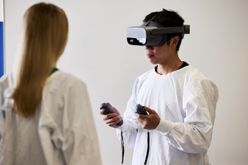 VRゴーグルを着けてコントローラーを操作する学生