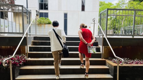 大学キャンパスの階段を上る留学生